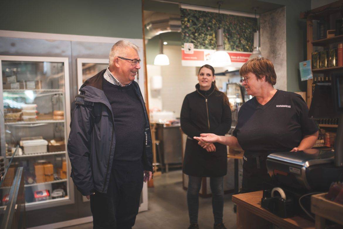 Man in winkel met twee dames in gesprek