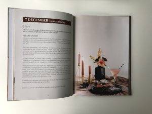 Een geopend boek met rechts een sfeervolle illustratie met kaarsen en bloemen en links een tekstgedeelte