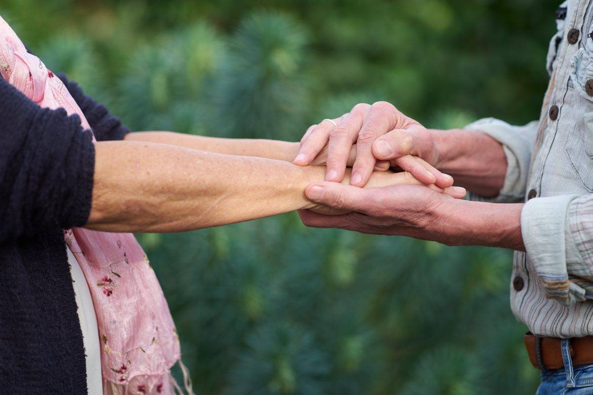 een man en vrouw raken elkaar aan met de handen. Je ziet alleen de armen en de handen.