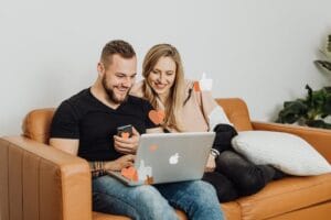 man en vrouw op de bank achter laptop